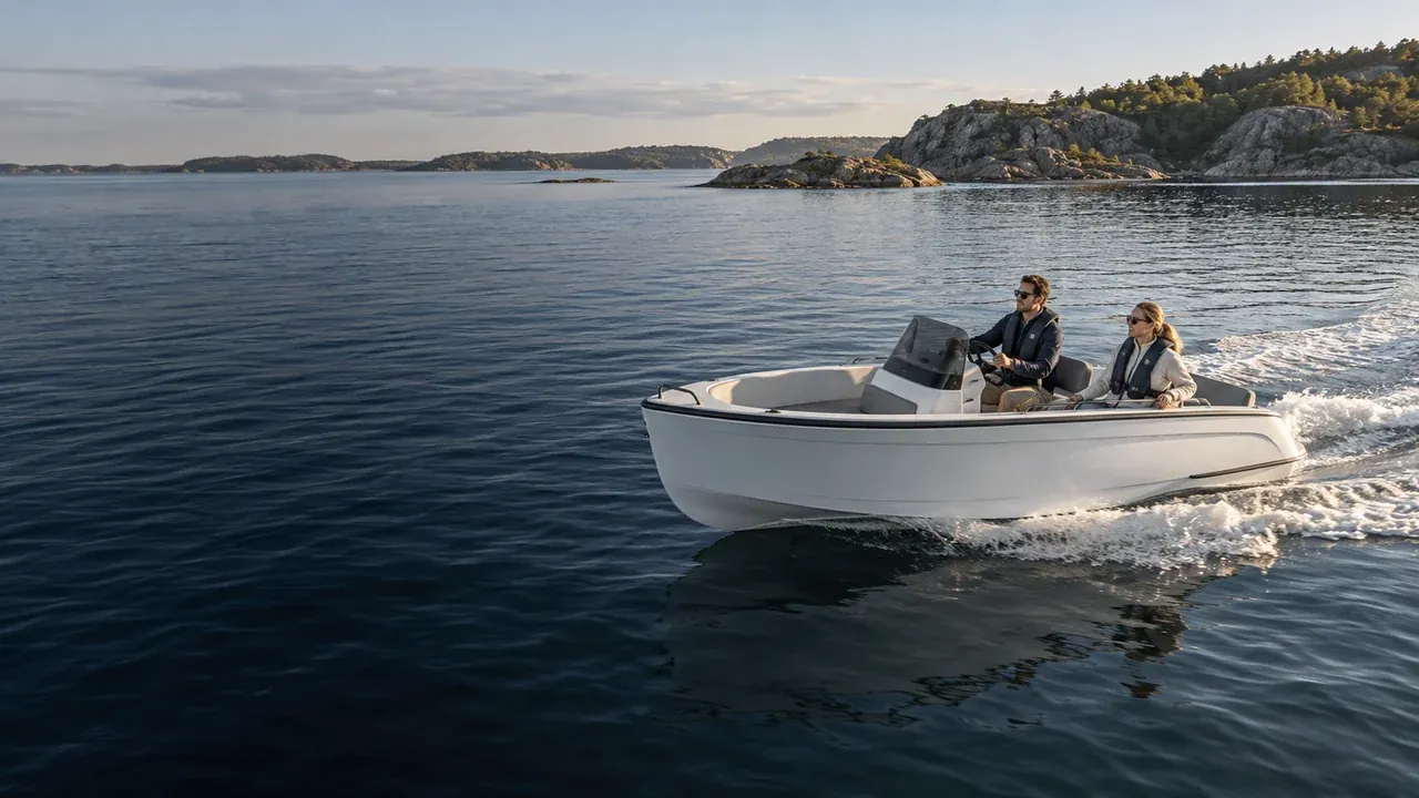 A small pleasure boat carrying two people through a coastal inlet